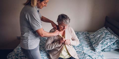 Home care attendant assisting an older woman.