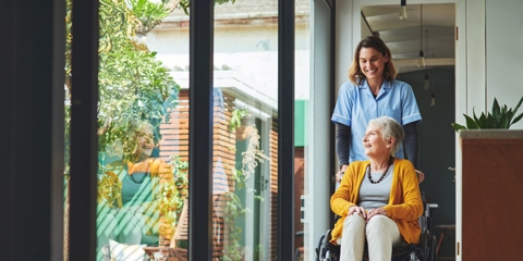 Nurse pushing a senior woman in a wheelchair.