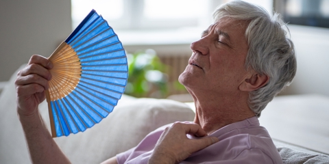Old man using fan