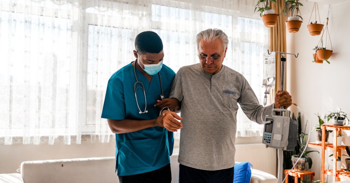 Home care attendant assisting an older man.