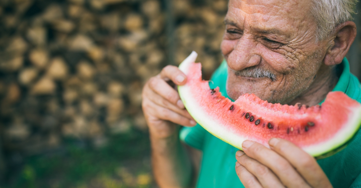 Old man eating watermelon
