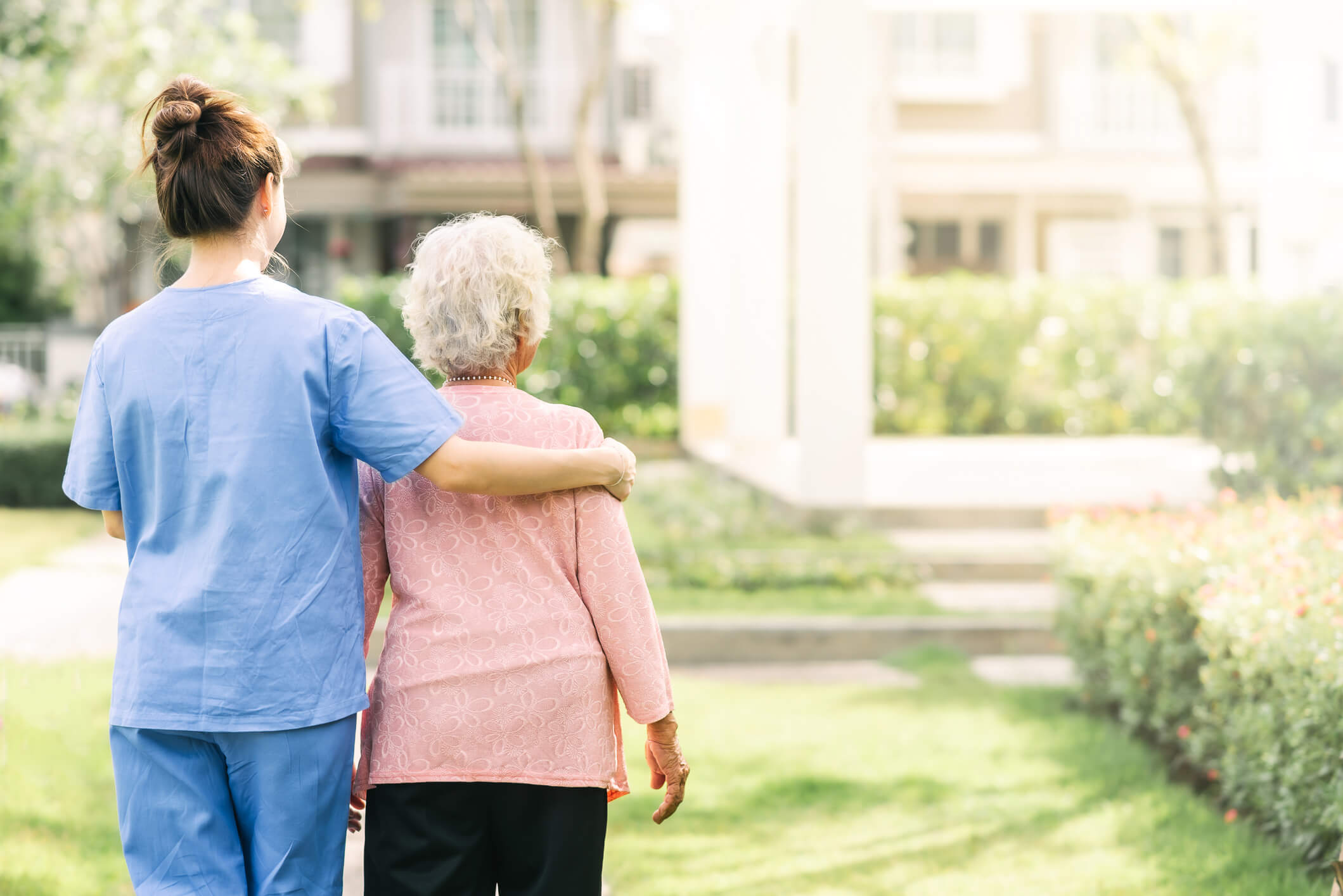 attendant helping an elderly woman