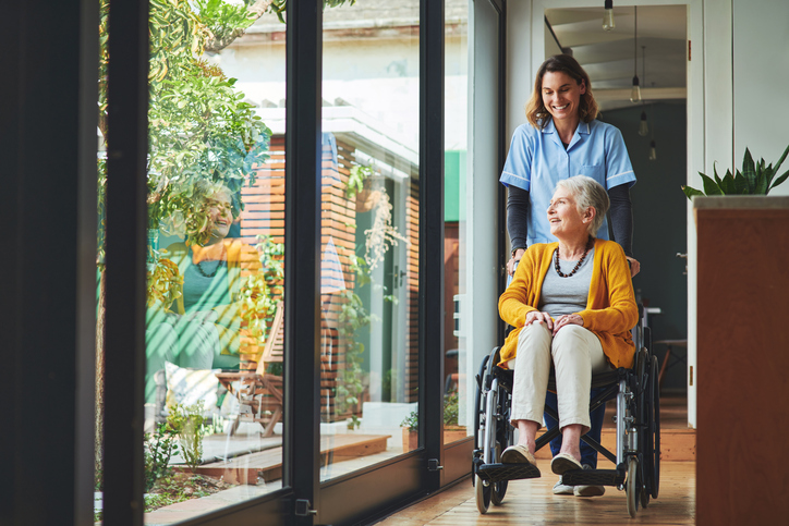 Nurse pushing a senior woman in a wheelchair.